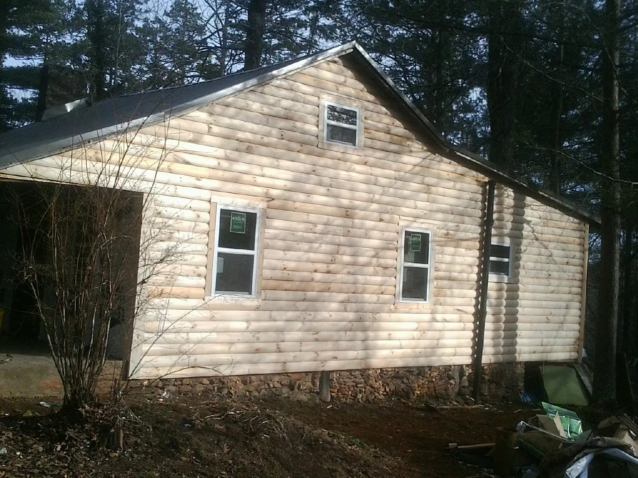 New log siding and dark metal roofing on a gable end in Mechanicsburg