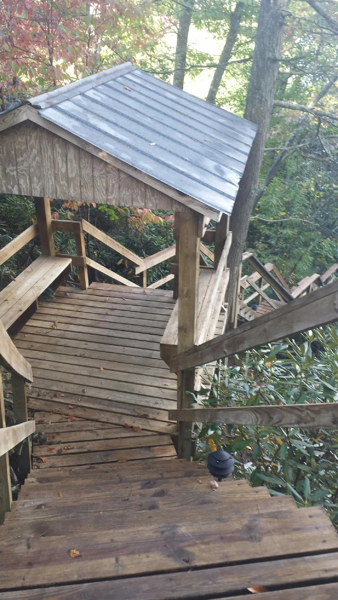 Metal roofed shelter over wooden steps on a wooded walkway — Skylight Repair & Installation work by our crew in Mechanicsburg